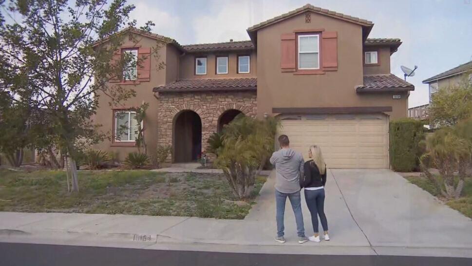 couple standing in front of house