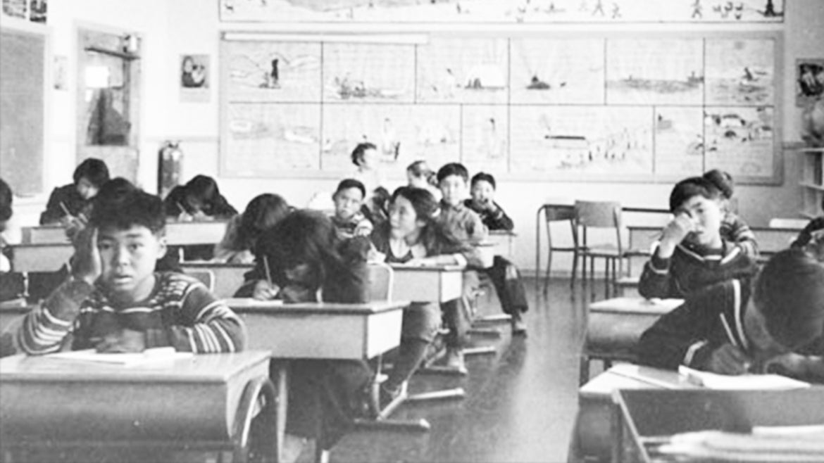 Young residential school students are photographed working at desks while at the Sir Joseph Bernier federal day school in Chesterfield Inlet, Nunavut.
