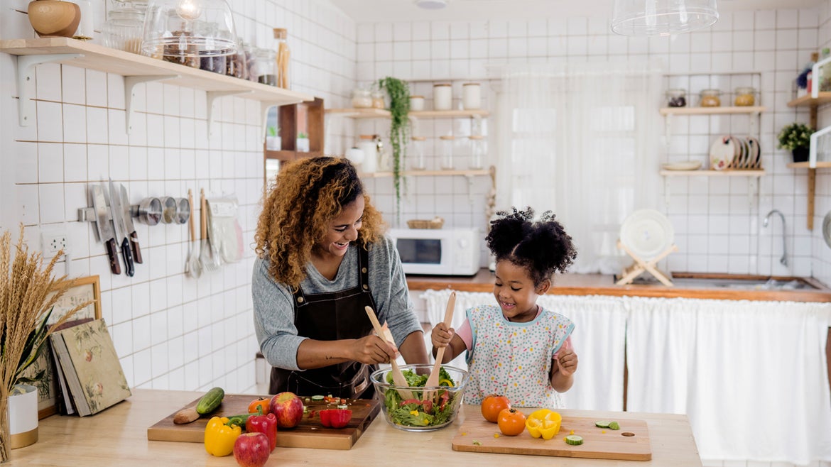 Mother and daughter cooking a meal in a kitchen.