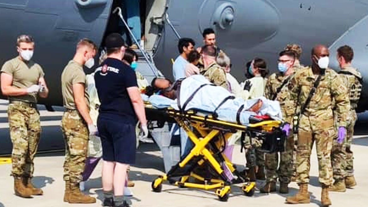 The pregnant woman is seen being helped off the plane by U.S. Airmen.