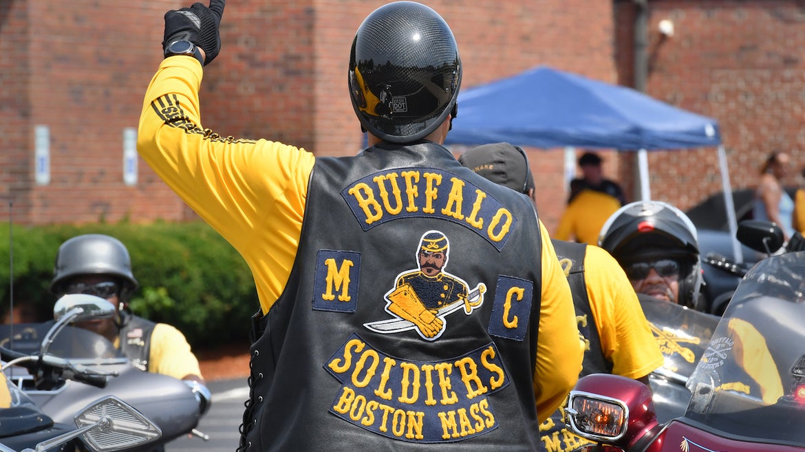 A member of the Buffalo Soldiers Motorcycle Club signals the riders to prepare for the 11th Annual "Buddy Run"l, benefiting the SPARK Center at Boston Medical Center.