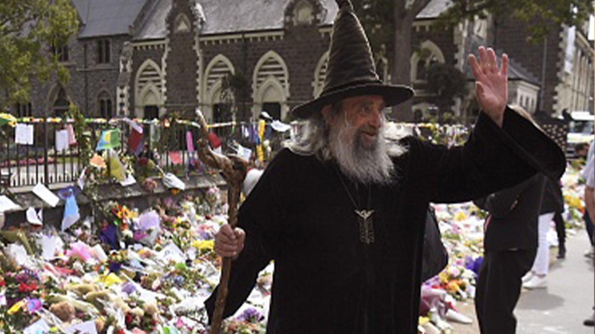 Ian Brackenbury Channell, known as the Wizard of New Zealand, waves in front of a memorial at the Botanic Gardens in Christchurch on March 21, 2019,