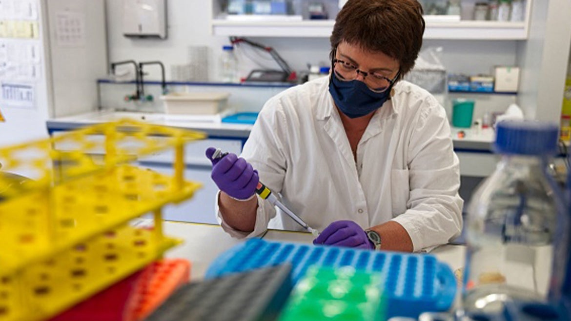Stock image of a researcher manipulating proteins in a laboratory.