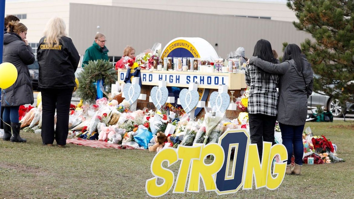 People gather at the memorial for the dead and wounded outside of Oxford High School in Oxford, Michigan on December 3, 2021. 