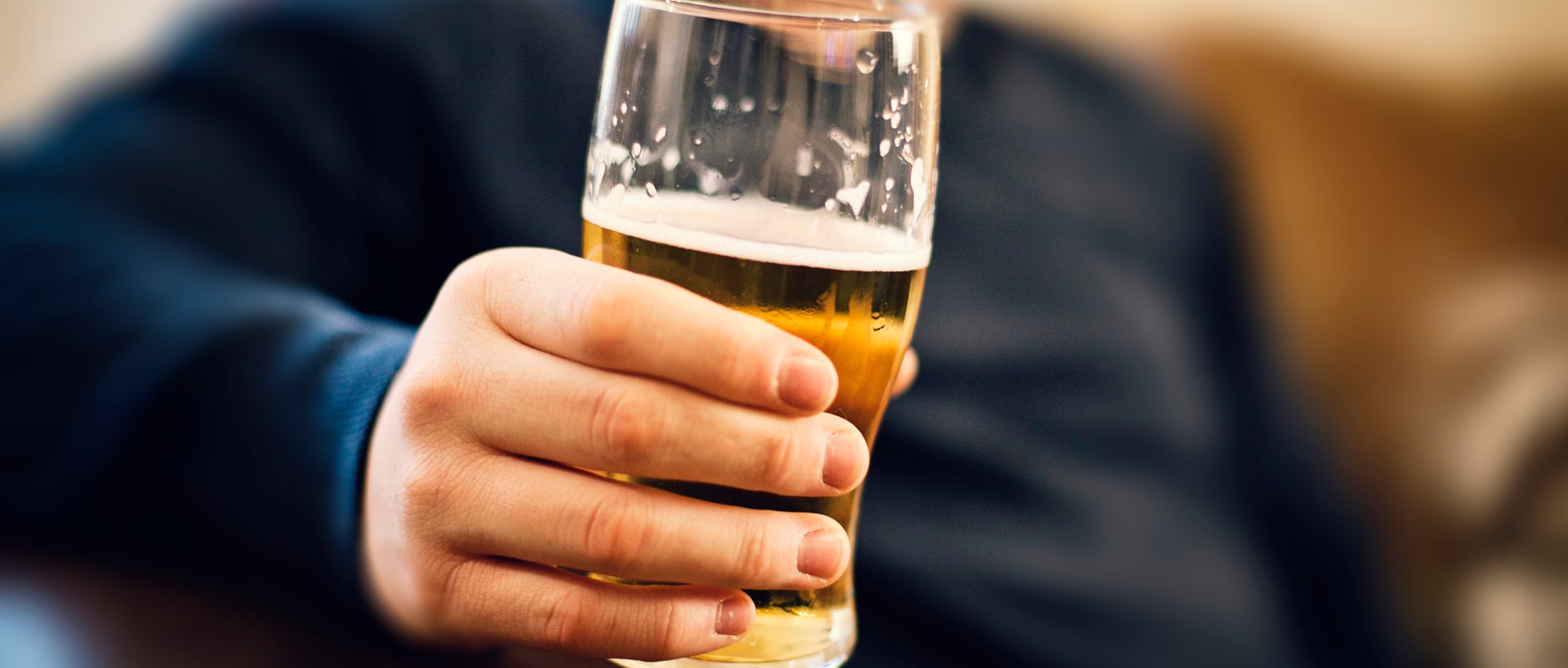 Hand holding a glass of beer