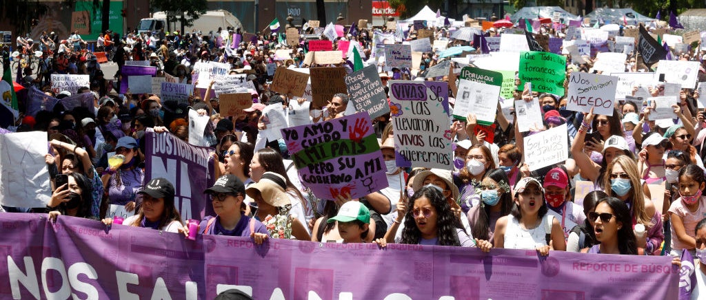 March in Mexico City with protestors holding purple sign about 24000 women killed