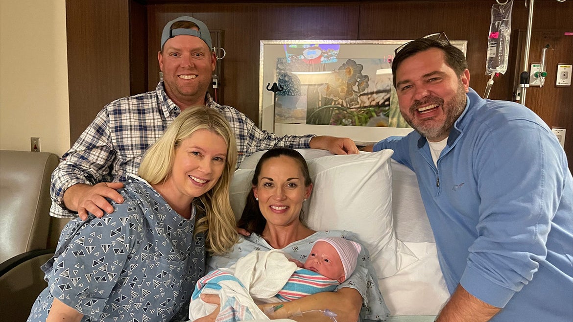 Surrogate and husband alongside new mom and dad