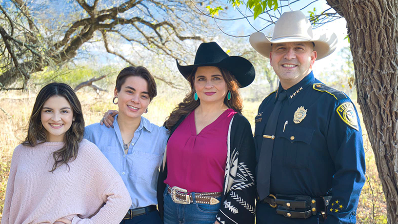 Sheriff Salazar standing to the right of people who appear to be his two daughters and wife.