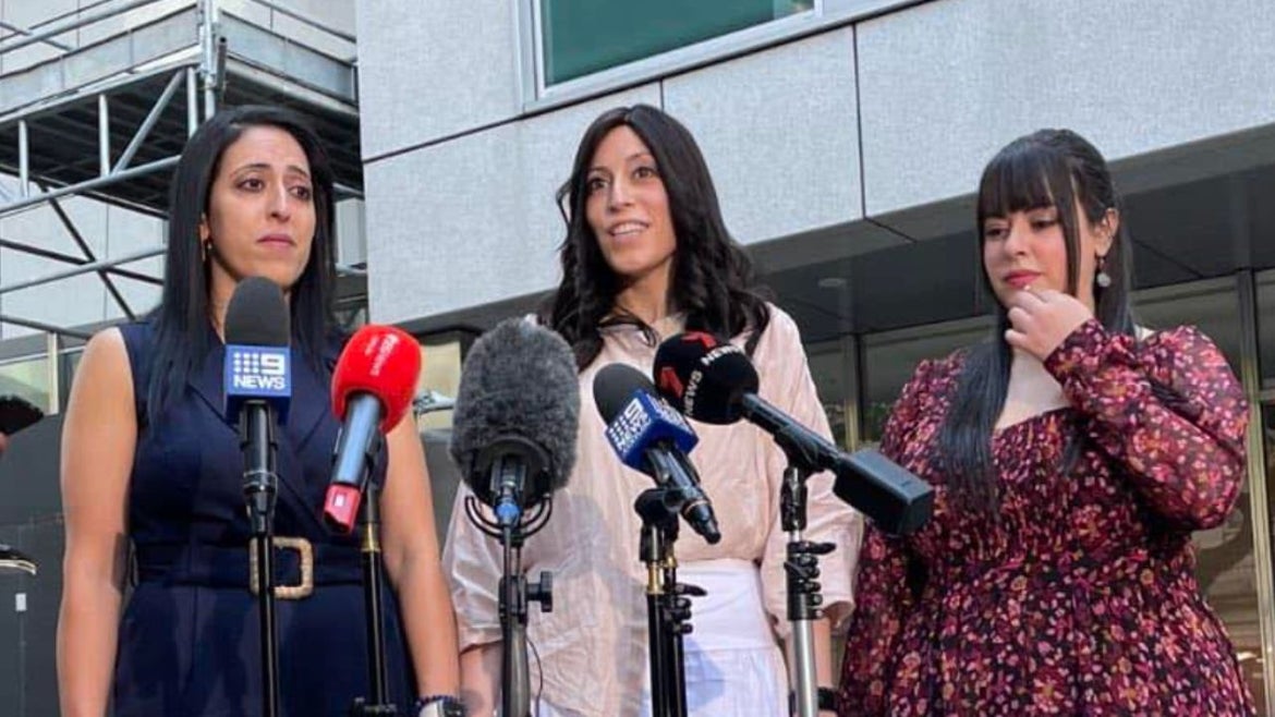thre women, the sisters, standing in front of many microphones from different press companies