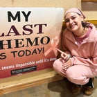 Cancer patient poses next to sign