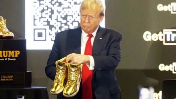 Donald Trump holds up gold sneakers