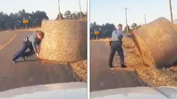 Trooper lifts large hay bale