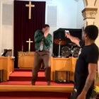 Gunman pointing gun at pastor