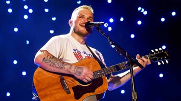 Zach Bryan playing guitar and singing in concert