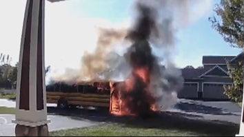 Home security camera footage of a school bus on fire on suburban street