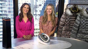 Two women standing behind a table displaying a Heater, Steam Iron, Puffer