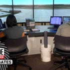 Two young adults sitting at an air traffic control station monitoring 