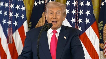 President Donald Trump speaking at a podium in front of a row of American flags
