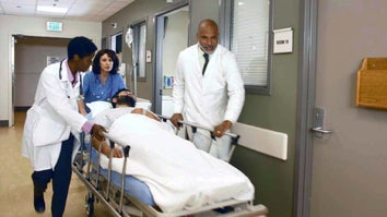 Two doctors and a nurse rushing a patient on a gurney down a hospital hallway