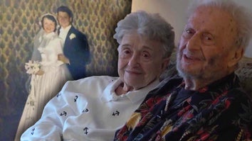 Elderly couple with wedding photo in background