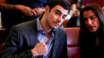 Luigi Mangione poses with clenched fist while conferring with woman in court