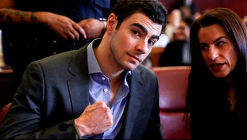 Luigi Mangione poses with clenched fist while conferring with woman in court