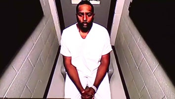 Sherrone Moore in a white jumpsuit wearing cuff as he appears virtually for court