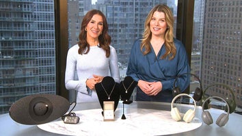 Two women standing behind a table displaying a Back Stretcher, Jewelry, Headphones
