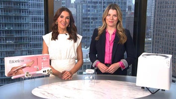Two women standing behind a table displaying a Shaving Kit, Earbuds, Air Purifier