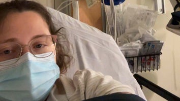 Woman wearing a surgical mask in a hospital bed