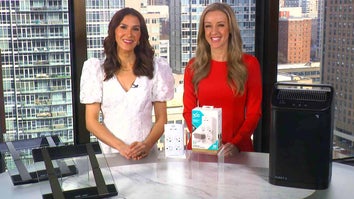 Two women standing behind a table displaying Scales, Charging Stations, Air Purifier