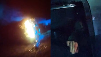 Car on fire, police officer pulling injured passenger from car