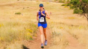 Woman wearing running gear while running through a field