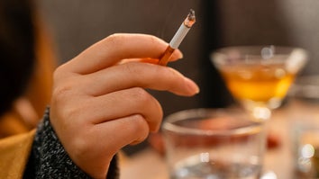 Young woman's hand holding a cigarette at a bar