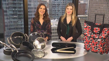 Two women standing behind a table displaying a Cookware Set, Flat Iron, Carry-On Luggage
