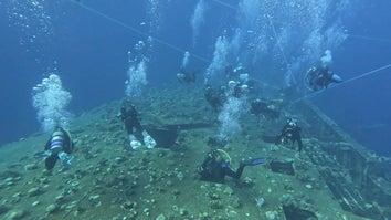 Divers exploring underwater wreckage