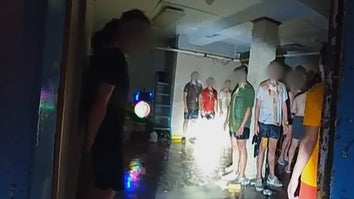 Police bodycam image of fraternity pledges in a basement