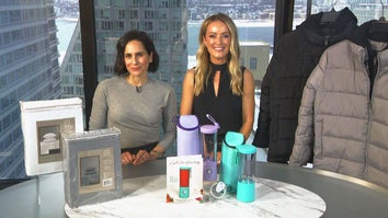 Two women behind a table displaying a Sheet Set, Portable Blender, Puffer Jacket
