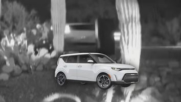 Home security camera footage of an obscured view of a car, possibly a KIA Soul (pictured below the video image)