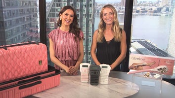 Two women standing behind a table displaying a Luggage Set, Label Maker, Shaving Kit