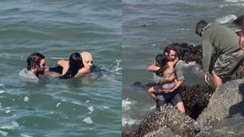 Two men and a child in ocean, man carries child out of ocean