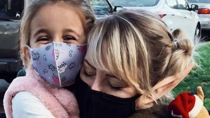 Kelly Kenney and Eliana pictured together in masks hugging
