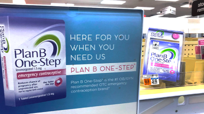 Image of a Plan B sign sitting next a Plan B box on the shelf of a drug store
