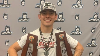 Miner smiling holding trophies