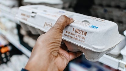 A stock image of a woman holding a carton of eggs.