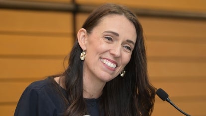 New Zealand’s Prime Minister Jacinda Arden standing at podium smiling