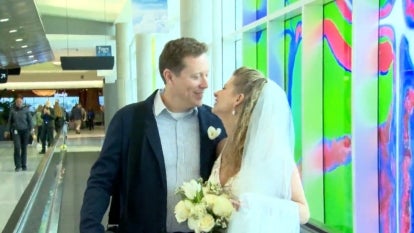 Lt. Commander Cylas Hensely and Lara Mark smiling at each other in the airport