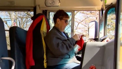 bus driver crocheting while sitting in bus driver seat