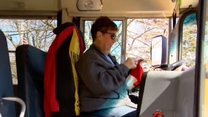 bus driver crocheting while sitting in bus driver seat