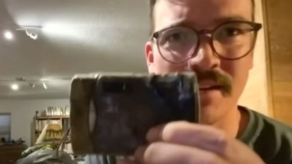 Spencer Greiner holding an old camera covered in dirt